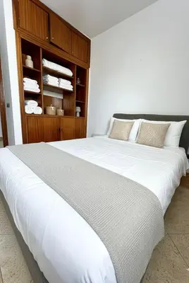 a large white bed in a room with a cabinet at Grand Appartement à Louer à Agdal, à Deux Pas de la Gare in Rabat