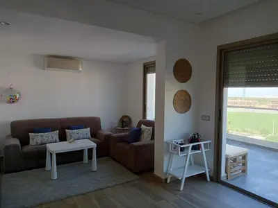a living room with a couch and a table at Blue Beach Residence Balnéaire pour familles in Sidi Rahal