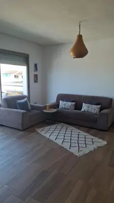 a living room with a couch and a rug at Blue Beach Residence Balnéaire pour familles in Sidi Rahal