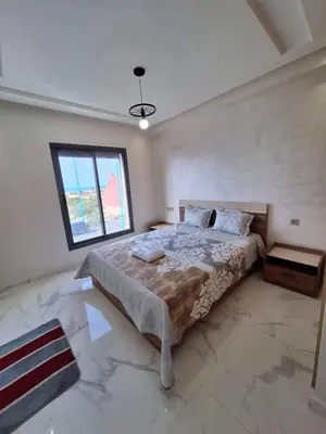 a bedroom with a large bed with a window at Sidi Rahal Appt raffiné, pieds dans l'eau in Sidi Rahal