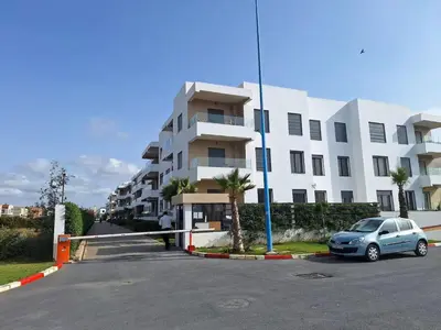 a car parked in a parking lot in front of a building at Sidi Rahal Appt raffiné, pieds dans l'eau in Sidi Rahal