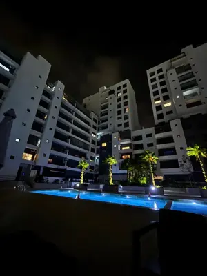 a swimming pool in front of some buildings at night at Morostay in Casablanca