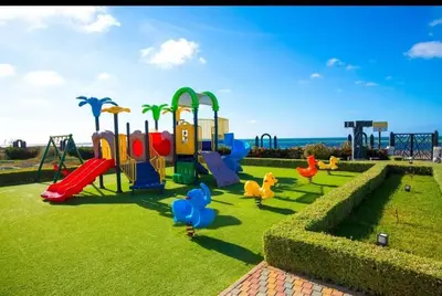 a park with a playground with ducks in the grass at Appartement Moderne très bien équipé pour familles seulement- Résidence Garden Bay Dar Bouazza in Tamaris