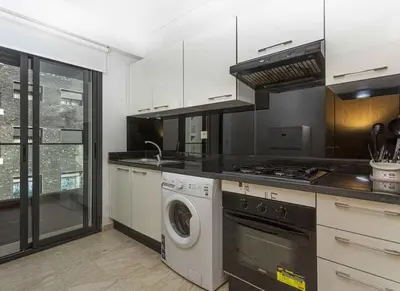 a kitchen with a washing machine and a stove at Appartement Moderne très bien équipé pour familles seulement- Résidence Garden Bay Dar Bouazza in Tamaris