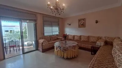 a living room with a couch and a table at Appartement moderne proche de la plage avec piscine in Skhirat