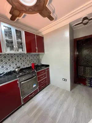 a kitchen with red cabinets and a ceiling at Séjour cosy à Palm Beach Mansouriah in Pont Blondin