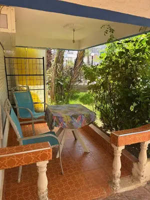 a porch with a table and a chair and a bench at Séjour cosy à Palm Beach Mansouriah in Pont Blondin