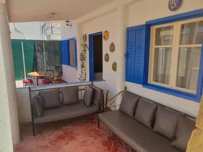 a living room with a couch and blue windows at Villa plage david in Kasba Bou Hamira