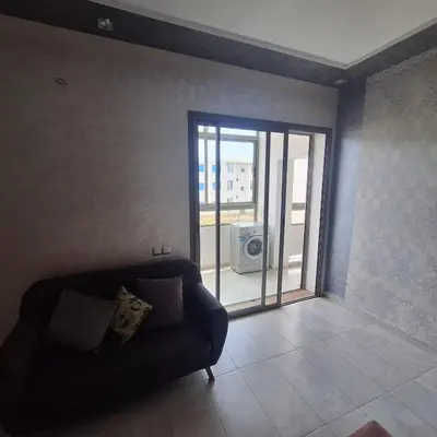 a living room with a couch and a sliding glass door at Appartement à 10min de la mer in Mansouria