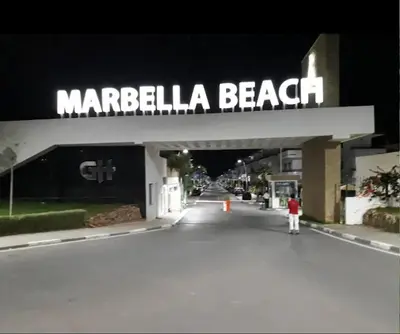a man standing in front of a marbella beach sign at Appartement à 10min de la mer in Mansouria