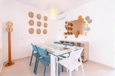 a dining room with a white table and blue chairs at Villa in Golf Resort with Shared Pool in Bouznika