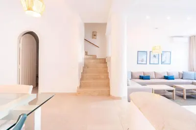 a white living room with a couch and a table at Villa in Golf Resort with Shared Pool in Bouznika