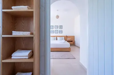 a bedroom with a bed and shelves with towels at Villa in Golf Resort with Shared Pool in Bouznika