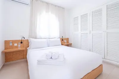 a bedroom with a white bed with towels on it at Villa in Golf Resort with Shared Pool in Bouznika