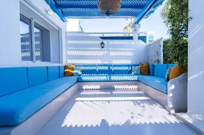 a patio with a blue couch and a window at Villa in Golf Resort with Shared Pool in Bouznika