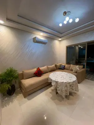 a living room with a couch and a table at Appartement Chaleureux in Bouznika