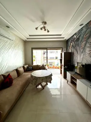 a living room with a couch and a table at Appartement Chaleureux in Bouznika