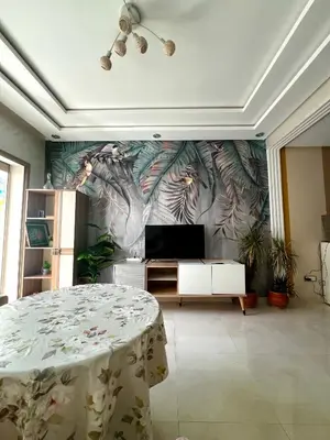 a living room with a table and a tv at Appartement Chaleureux in Bouznika