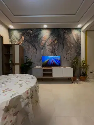 a bedroom with a flat screen tv on a wall at Appartement Chaleureux in Bouznika