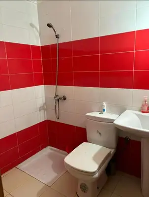 a red and white bathroom with a toilet and a sink at Appartement sidi rehal l'ocean in Sidi Rahal