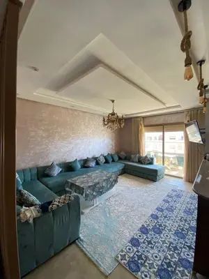 a living room with a blue couch and a rug at Appartement dans une résidence fermée, Malaga Beach in Mohammedia