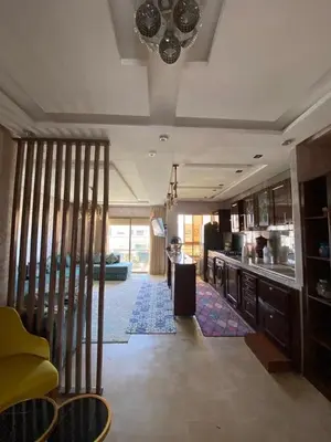 a living room with a kitchen and a dining room at Appartement dans une résidence fermée, Malaga Beach in Mohammedia