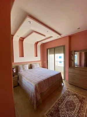 a bedroom with a large bed and a window at Appartement dans une résidence fermée, Malaga Beach in Mohammedia