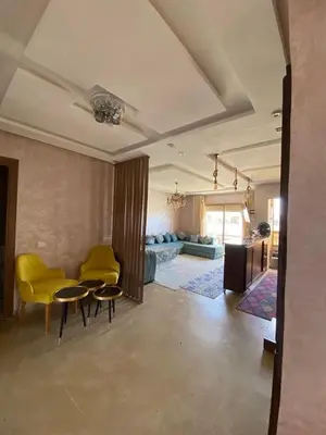 a living room with yellow chairs and a couch at Appartement dans une résidence fermée, Malaga Beach in Mohammedia