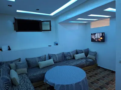 a living room with a couch and a tv at La Pause Dar Bouazza in Tamaris