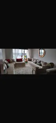 a living room with couches and a mirror at Appartement avec piscine in Temara