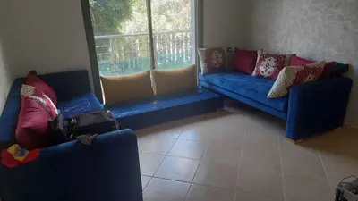 a living room with blue couches and a window at El Mansouria Mohammedia Casablanca in Pont Blondin