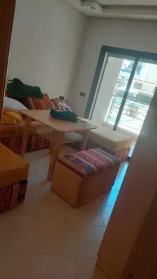 a living room with a wooden table and a window at El Mansouria Mohammedia Casablanca in Pont Blondin