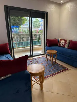 a living room with a blue couch and a table at El Mansouria Mohammedia Casablanca in Pont Blondin