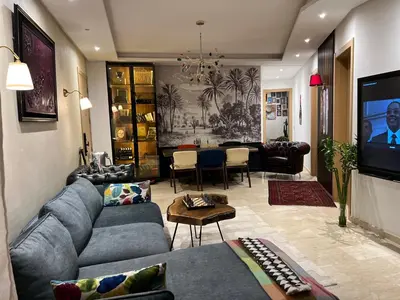 a living room with a couch and a dining room at Logement 5 etoiles avec piscine et jardin privée à rabat hay riad in Rabat