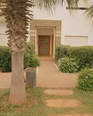 a palm tree in front of a building with a door at Perfect Family Apartment in Tamaris