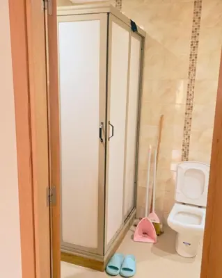 a bathroom with a toilet and a cabinet with slippers at Perfect Family Apartment in Tamaris