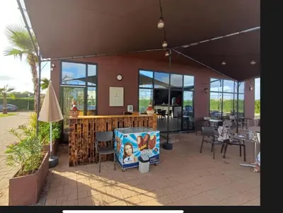 a restaurant with a patio with tables and chairs at Appartement vue piscine - Pour Famille - Blue Beach SIDI RAHAL in Sidi Rahal