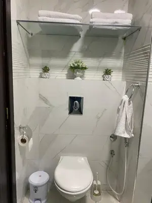 a white bathroom with a toilet and towels at Appartement deux chambre confortable près de la Gare - Restau - cafes - Plage in Casablanca