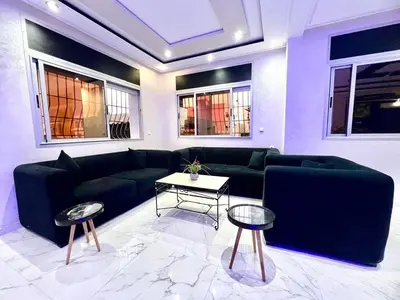 a living room with a couch and tables and windows at Rabat sidi yahya zaër in Sidi Yahia az Zaʼer