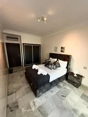 a bedroom with a large bed with white sheets and pillows at Charmant Appart 5 minutes de La Plage Sablette in Mohammedia