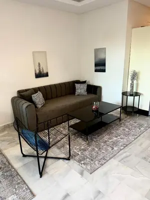 a living room with a couch and a table at Charmant Appart 5 minutes de La Plage Sablette in Mohammedia