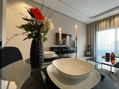 a dining room with a table with a vase with roses at A 1 pas de Zara Magnifique Studio Premium in Casablanca