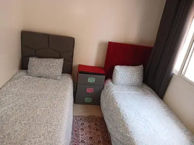 a bedroom with two beds and a window at Kettani bouznika in Bouznika