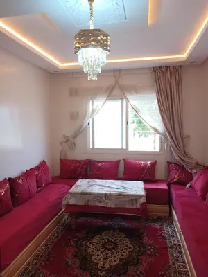 a living room with a red couch and a chandelier at Kettani bouznika in Bouznika