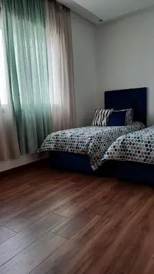 a bedroom with two beds and a wooden floor at Luxury family villa in Casablanca