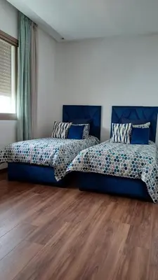 a bedroom with two beds and a wooden floor at Luxury family villa in Casablanca