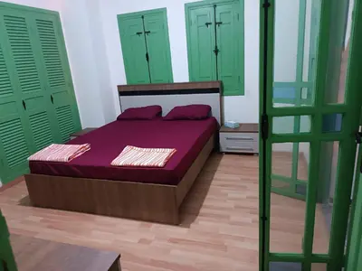 a bedroom with green doors and a bed with purple sheets at Green house in Sidi Yahia az Zaʼer