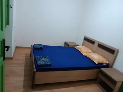 a bed in a room with blue sheets and pillows at Green house in Sidi Yahia az Zaʼer