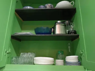 a green cabinet with plates and cups and dishes at Green house in Sidi Yahia az Zaʼer
