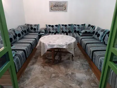 a living room with a table and a couch at Green house in Sidi Yahia az Zaʼer